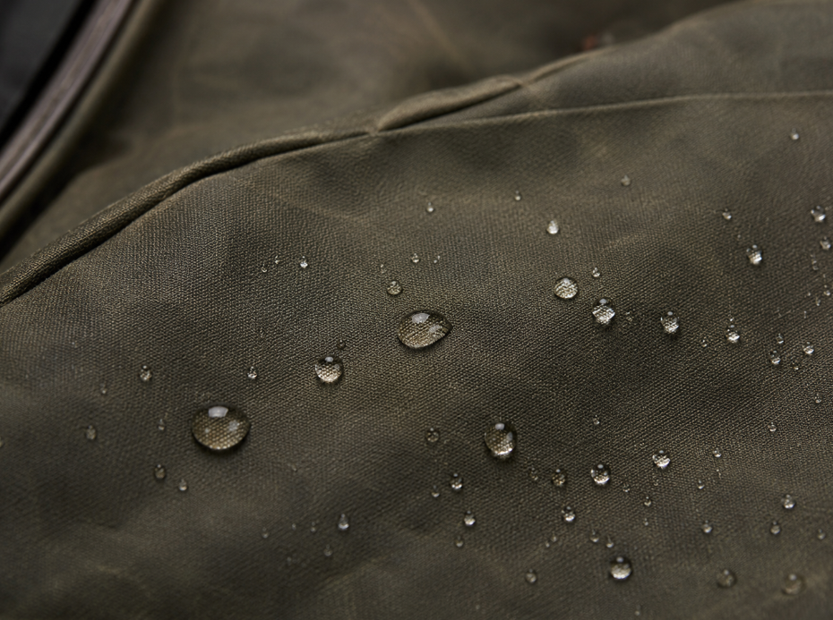 Water repellent fabric with water droplets beading on waxed canvas surface