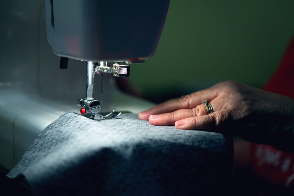 a person sewing with a sewing maching