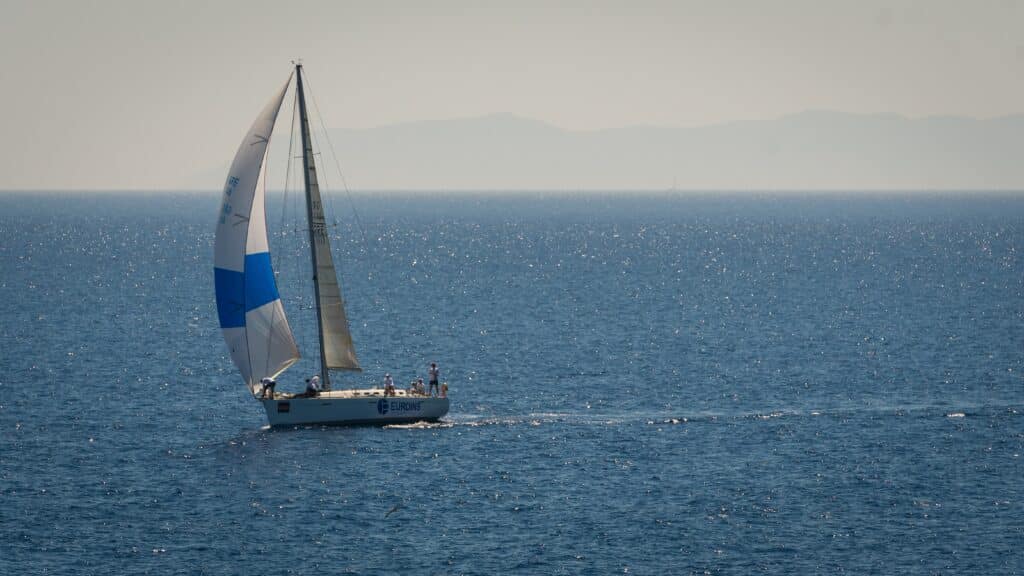 Beautiful sail boat with white and blue canvas sail
