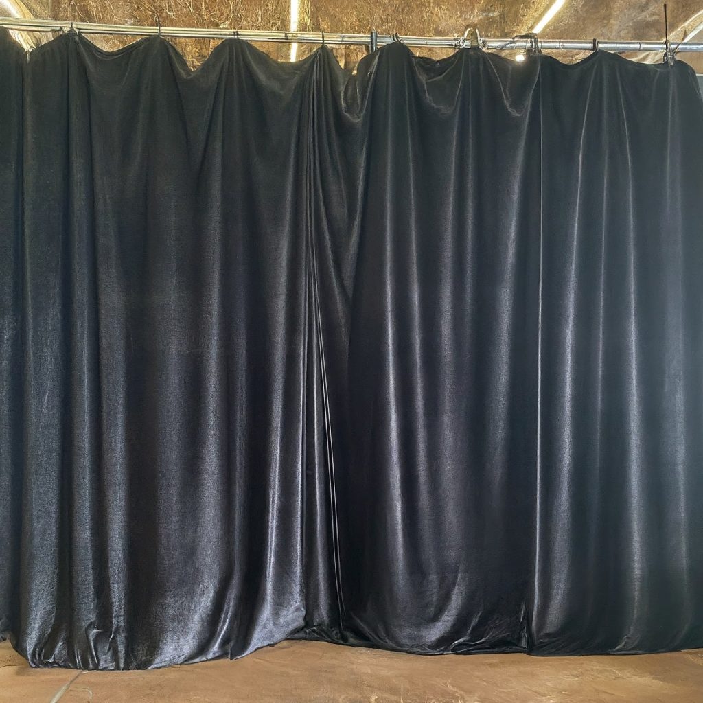 Black velvet theatrical backdrop hung on a pipe and drape frame