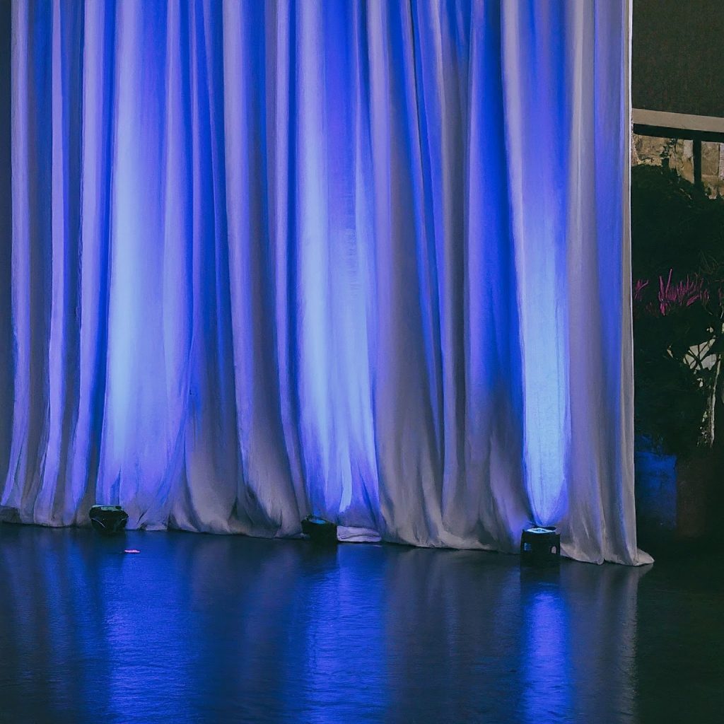 A before-and-after photo of a plain white pipe and drape backdrop transformed with vibrant blue lighting