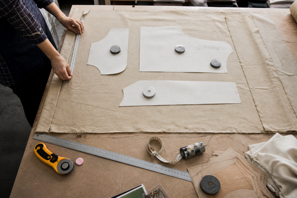 A top-down cutting table scene with pattern pieces arranged on fabric to show how a fixed roll end may or may not fit the project layout.